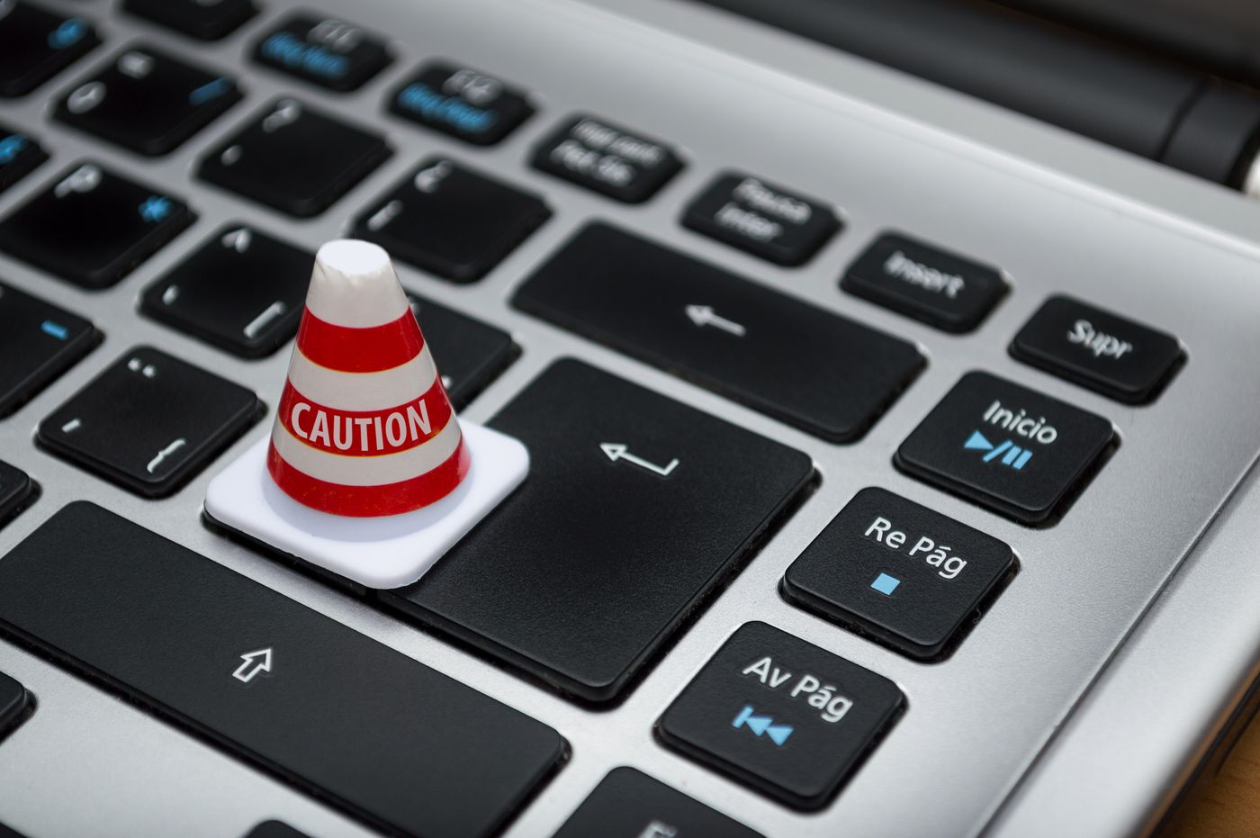 Un petit cône de signalisation « caution » posé sur la touche entrée d’un clavier d’ordinateur portable